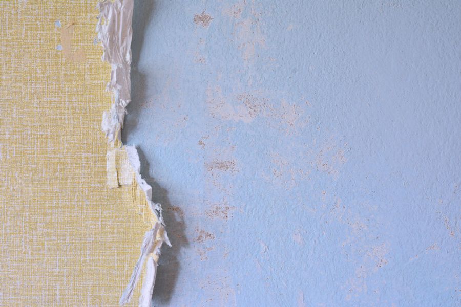 Blue wall with partially-removed yellow wallpaper